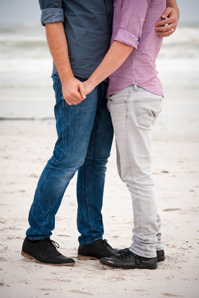 gay couple taking a walk along the beach holding hands