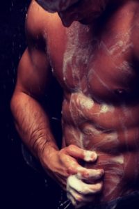 Handsome muscular man at the shower.